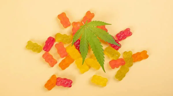 Colorful CBD gummy bears with a hemp leaf